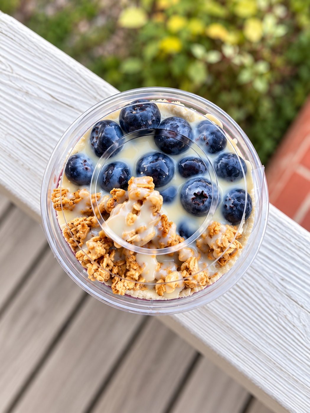Açaí cup with strawberry, blueberry and granola at sunset